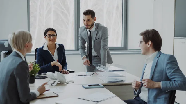 Group of professionals in a modern office setting discussing business strategies. Selling software or selling data: where prospecting software commercial opportunities really sit