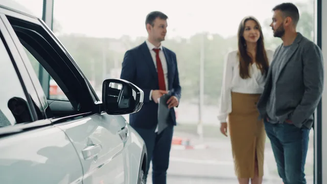 Salesperson consulting couple in a modern car showroom. What should prospecting software competitor research cover?