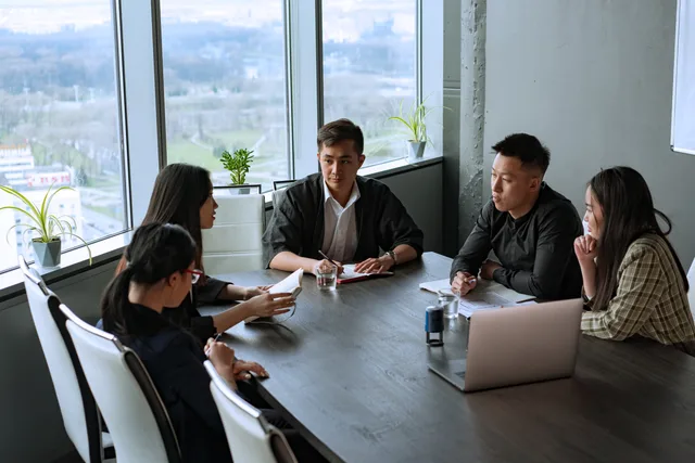 Group of Asian professionals having a meeting in a modern office setting. Prospecting software demand signals explained for sales teams