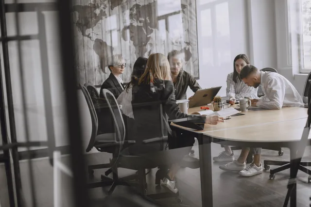 Professionals in a meeting room engaged in a collaborative business discussion. How to assess prospecting software launch claims