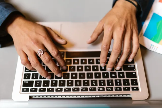 Hands typing on a laptop with a ring, emphasizing technology and work. Why prospecting software compliance rules must be set before you scale